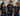 Three healthcare workers wearing matching navy blue scrubs and t-shirts with a 'Black Cloud Social Club' graphic, standing in a hospital corridor.