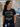 A woman in a hospital or clinic setting wearing a navy blue graphic t-shirt that reads 'BLACK CLOUD SOCIAL CLUB' with a cloud graphic wearing sunglasses, paired with navy scrub pants.